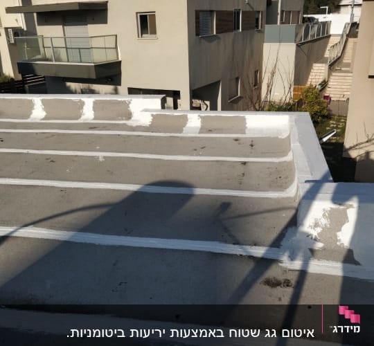 גג אטום עם פסי איטום לבנים על בטון אפור